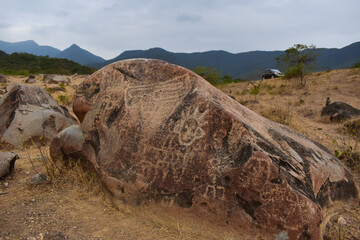 Carved rocks with ancient petroglyphs created by a past culture, a testament to early human artistry and symbolism.