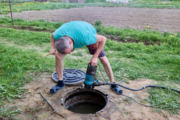 Septic tank is an underground storage tank for sewage waste, worker pumping wastewater with sewer...