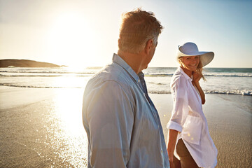 Senior, happy couple and walking with beach sunset for love, embrace or bonding together in nature....