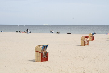 Beach view with sandy beach and typical german Strandkorbs in north of the Germany, pastel colors, calm still life photo with sea