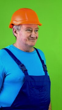 Senior worker in overalls and helmet says yes, nods head and looking at camera.