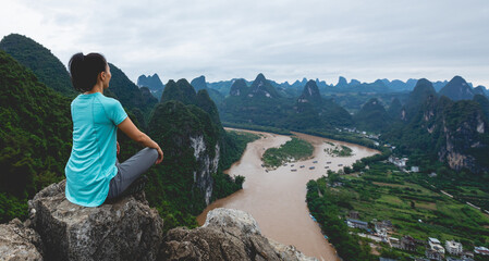 Woman meditating at the beautiful landscape of yangshuo county, China