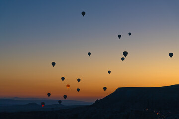 Magnificent sunrise with balloons in Cappadocia, Turkey. Beautiful landscape with silhouettes of balloons at dawn against a charming sky background.