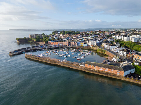 An aerial image of Paignton harbour on a clear sunny morning with blue skies and a calm sea