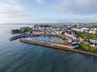 Obraz premium An aerial image of Paignton harbour on a clear sunny morning with blue skies and a calm sea