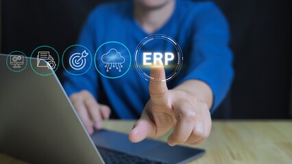 Businessman use laptop to analyzing ERP system on virtual screen.ERP, Enterprise resource planning concept. Connections between business intelligence, HR and CRM modules.