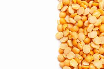 Uncooked, yellow peas border on white background. Copy space for text. Top view