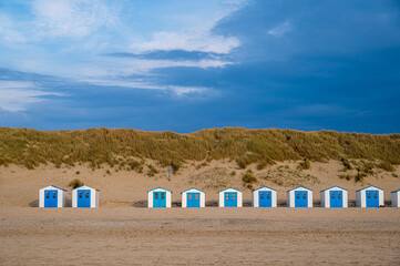 Weiß-Blaue Strandhäuser im Abendlich am Strand auf der Nordseeinsel Texel