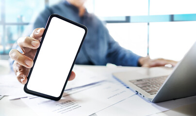 Close-up shot, asian businessman holding mobile phone working with laptop at office workplace, concept of use wireless connection technology via internet to working online