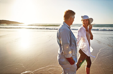 Happy couple, walk and holding hands on beach for holiday on island or coast for getaway, travel...