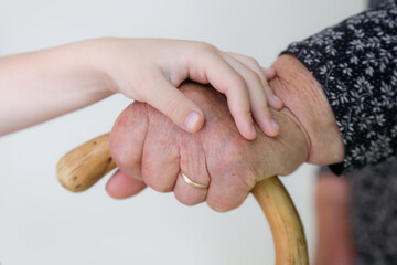Great grandma and great granddaughter holding hands showing love and affection, close up