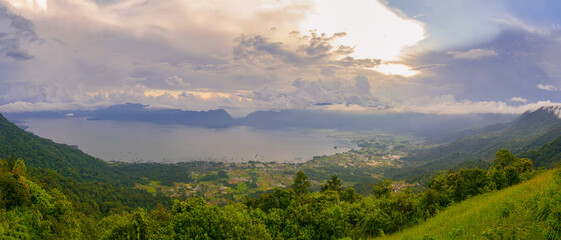 Expansive Panorama of Danau Maninjau at Sunset, Lush Mountains Embrace the Quiet Wate ; indonesia tourism
