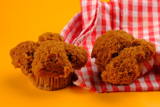 bolu kukus gula merah (gula jawa) is an Indonesian traditional snack of steamed sponge cupcake. served on yellow table. Indonesian food. sweet dessert. 