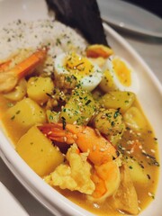 Shrimps in curry sauce and rice on a plate. horizontal view from above