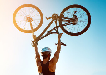 Man, outdoor and bicycle for achievement or celebration, personal goal and fitness milestone or accomplishment of trail riding. Person, back view and lifting bike in sky for success, victory and joy.