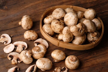 champignons are edible mushrooms that are almost round like buttons. mushroom is the most widely cultivated mushroom in the world. Agaricus bisporus. served on a rustic wooden table. 