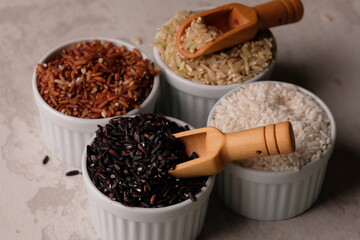 various rice in a white ceramic bowl. There are brown rice, black rice, brown and white. Rice is the staple food of most Asians. Oryza sativa. beras merah, beras hitam, beras coklat. 