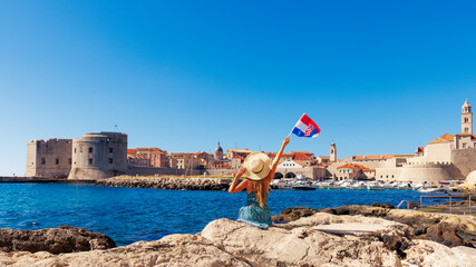 Happy female holding croat flag, enjoying panoramic view of Dubrovnik city landscape- Croatia