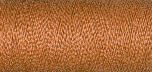 macro texture of a skein of orange sewing thread