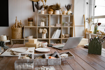 Empty decor and ceramic tableware retail store. Workplace with laptop and phone lying on table...