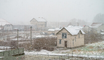 Snow and a blizzard in the village. Inclement weather with snow and rain in the countryside.