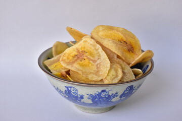 Banana chips with a sweet and salty taste made from fried raw bananas in a bowl. Traditional snacks. Crispy Banana Chips, fried or baked sliced banana. 