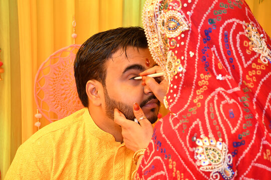 Woman applying eyeliner to a man