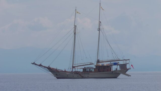 two-masted sailboat anchored near Kri Island, Raja Ampat, Indonesia. Static shot.