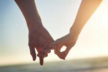 Couple, holding hands and little finger at beach in close up with bonding, love and connection on...
