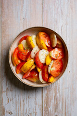 Top view of a tomato, peach and cucumber salad. Minimalist food style.