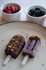 Homemade blackberry and raspberry ice cream with chocolate and chopped nuts. Minimalist dish