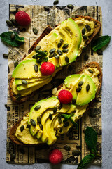 Bread toast with hummus and avocado, on a decorative paper. Decorated homemade food concept.