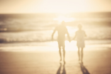 Couple, holding hands and walk at beach with silhouette for bonding, love or connection on...