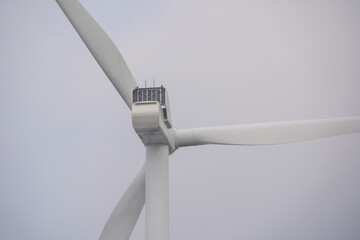 Windmill Power Turbine Against Grey Sky Background.