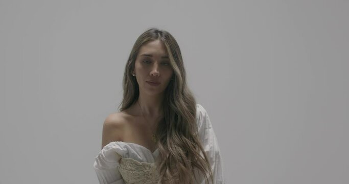 Latin girl Wearing white dress with cleavage in Indoor Studio for Stock Content Production