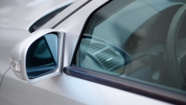 Close up of the mirror and the front window of a silver car