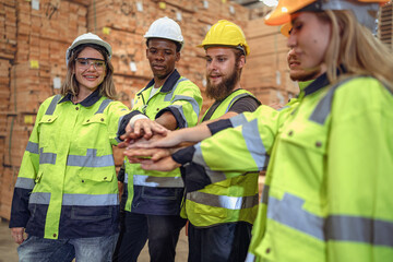 Group of diverse people wear safety helmet and vest uniform standing in factory. Young women...
