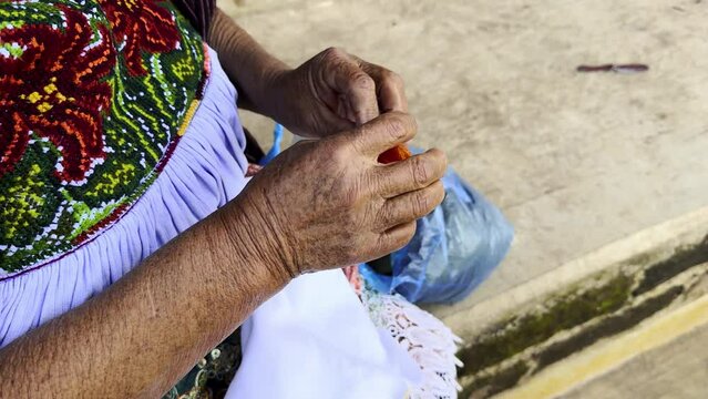 Mexican craftswoman sitting knitting in Michoacan