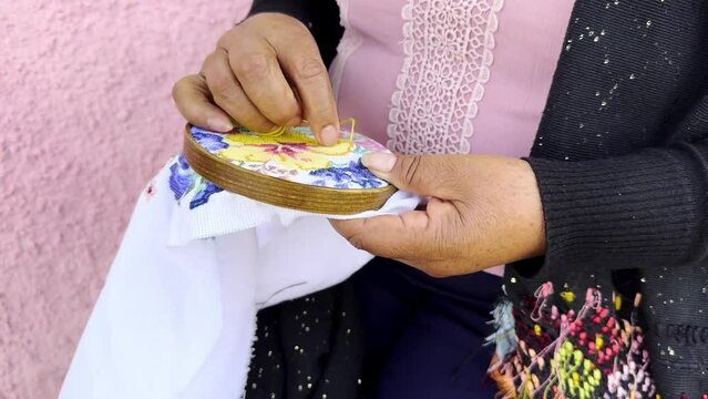 Mexican craftswoman knitting seated in Michoacan