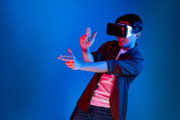 Smart gamer wearing VR turning to metaverse world playing gun shooting hunter isolated blue neon...