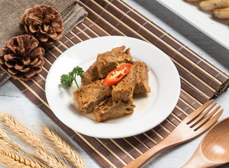 Five spiced dried beans taiwan with wheat, spoon and fork served in dish isolated on napkin side view of taiwanese food