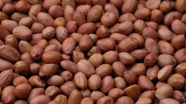 Zoom frame heap of raw peanuts, rotation. Healthy food concept