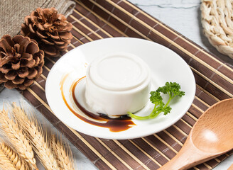 coconut pudding or Peanut tofu curd with wheat, spoon and fork served in dish isolated on napkin side view of taiwanese food