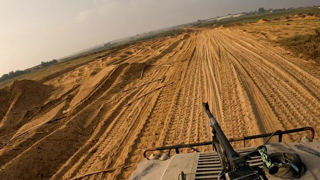 Israeli Humvee Patrol racing along a gravel rood through open country in Gaza