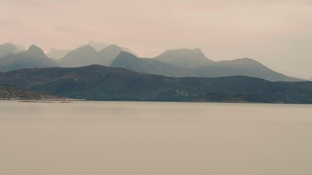 Mountainous fjord cost wrapped in thick fog. Parallax dolly shot