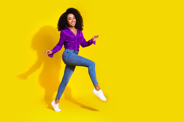 Full body photo of lovely young lady running have fun empty space dressed stylish violet garment isolated on yellow color background