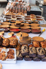 Close-up of a table in a street market shop full of sweets and homemade cakes on a white tablecloth. basque food