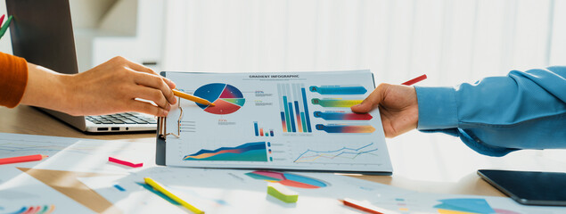 Startup company employee working together, analyzing BI dashboard paper on financial data report...