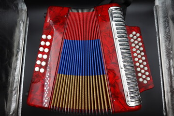 A vibrant red Colombian vallenato accordion featuring the colors of the Colombian flag (red,...