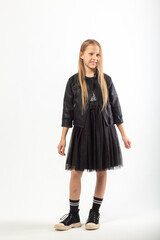 A full-length portrait of a young girl with long brown hair dressed in a hooligan style.